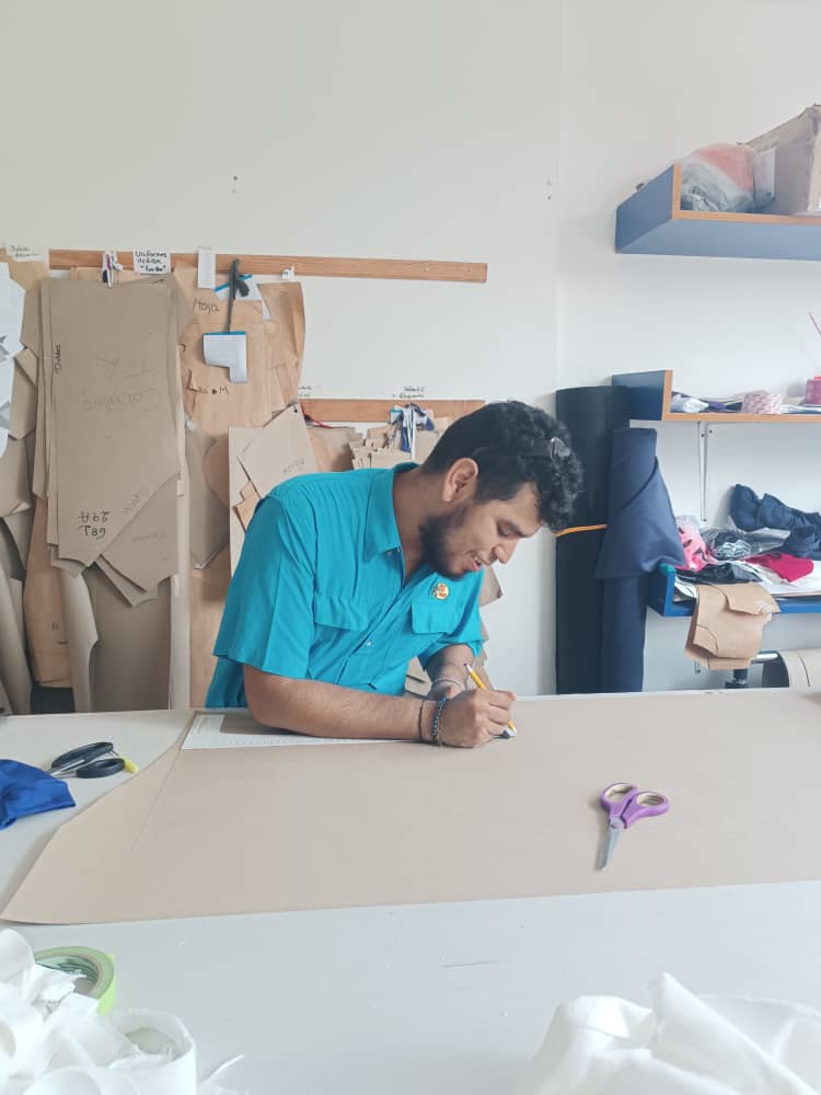 Marcos Lius Negrin trazando un patrón sobre papel en su taller